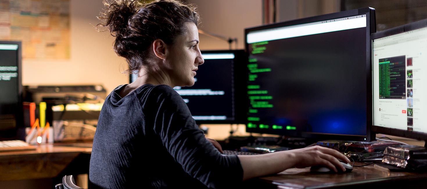 woman looking at code on a computer