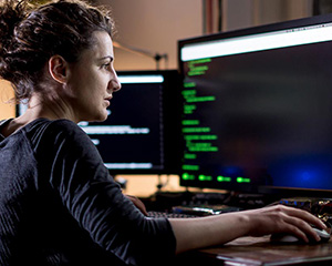 woman looking at code on a computer