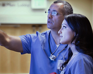 Nurse looking at a whiteboard with a colleague