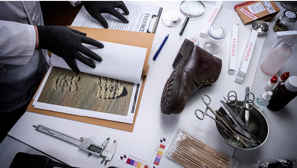 Scientist comparing a footprint to the tread of a boot in a crime scene investigation