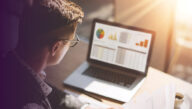 View from behind of man examining a webpage of charts and data