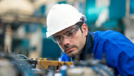 Mechanical engineering technician examining heavy equipment