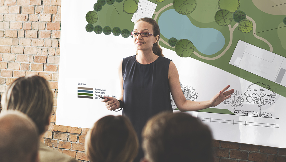 Woman presenting plans for a park in a public forum