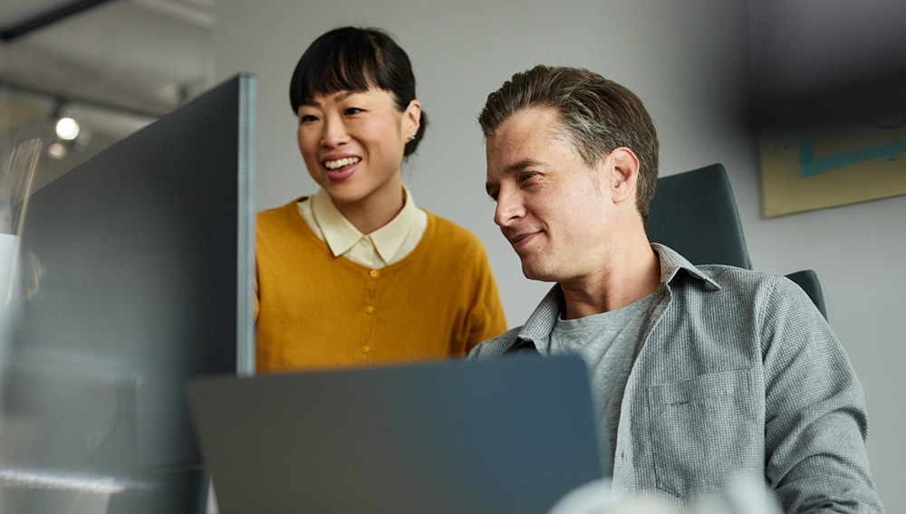 Tech industry co-workers looking at the same computer screen